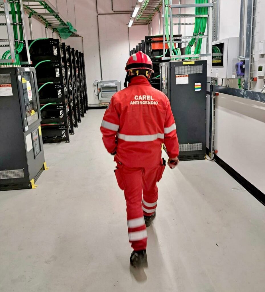 personale di carel antincendio che cammina con tuta rossa